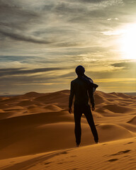 Fototapeta na wymiar silhouette of man walking on in the desert