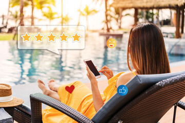 Young woman relaxing at resort pool and using smartphone to give a five-star satisfaction rating of the hotel's service and rooms on social media. Travel lifestyle concept