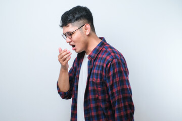 Young asian man smelling something stinky and disgusting, intolerable smell, holding breath with fingers on nose. Bad smell