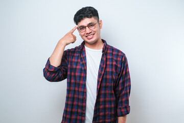 Handsome young man wearing casual shirt smiling pointing to head with hands finger