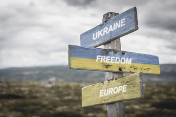 ukraine freedom europe text quote on wooden signpost outdoors in nature. War in ukraine concept.