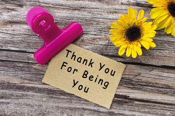Thank you for being you text on torn paper with clip holder on wooden surface.