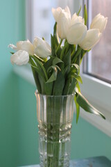 bouquet of white delicate tulips in a vase at sunset
