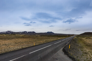 A road through no vegetation but only moss covered fields of Northern Iceland