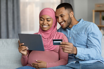Black Muslim Pregnant Couple With Digital Tablet And Credit Card Shopping Online