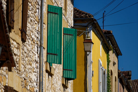 Photos of several houses with shutters colored in yellow, red and green, bastide town of Monpazier in Périgord