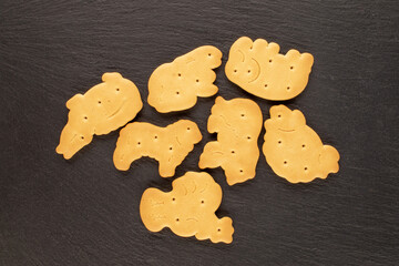 Several homemade zoological cookies on a slate stone, close-up, top view.