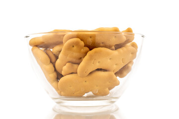 Several zoological biscuits in a glass dish, close-up, isolated on a white background.