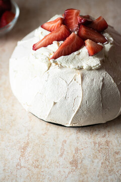 Summer fruit pavlova - famous Australian dessert from baked whipped egg whites and cream cheese filling with strawberries.