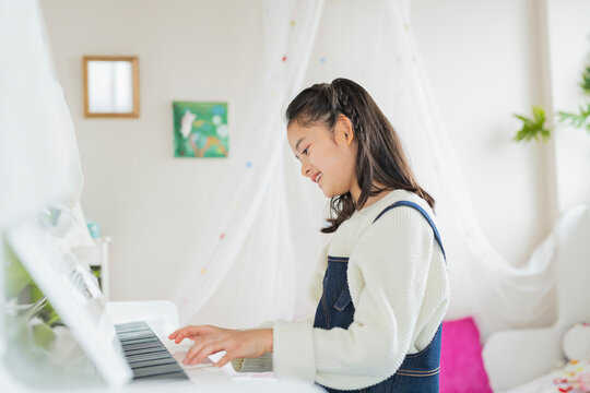 部屋でピアノを弾く女の子