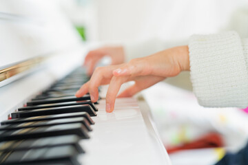 部屋でピアノを弾く女の子 © One