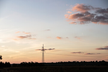 High voltage power line at dusk. Green energy with renewable resources.