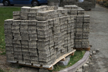 A pallet of gray paving stones. Construction and repair of the road. City street after destruction.
