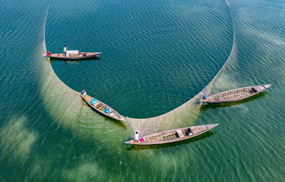 Local fishermen are fishing in river with huge net. Aerial View taken with drone.