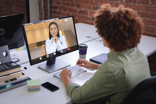 Biracial Businessman Attending Meeting With Asian Woman Through Desktop Pc In Office