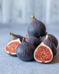 Fig fruits, whole and halves, on a gray background