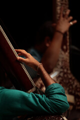 Close up of hand playing string instrument Tanpura.