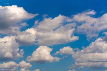 Naklejka na ściany i meble Beautiful white clouds on a bright blue background.
