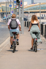 A young man and a girl are riding bicycles. Cyclists on the city street.