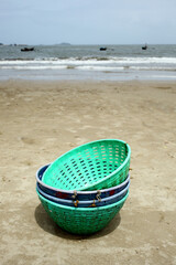 Fish collecting plastic baskets on Karwar beach, Karnataka, India.