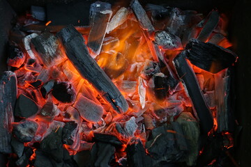 Charcoal is smoldering in the grill for cooking. Ashes, heat, smoke and fire of coals. Burning...