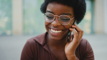 Pretty dark-skinned female in glasses having conversation with f