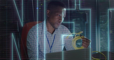 Animation of nft text over african american man using laptop in server room - Powered by Adobe