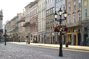 Traditional houses on a pedestrian street in the historic Old Town of Lviv, Ukraine. lanterns and many flowers. May 2021