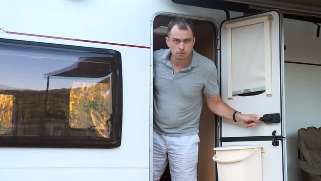 The Angry Suspicious Man Walks Out The Door Of Camper Van To The Uninvited Guests. Road Conflict. Problem In Travel Trip. 