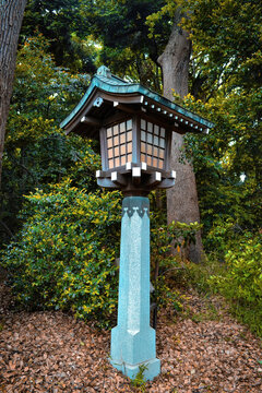 Traditional Japanese wooden lantern.Japanese style lampost on walking passage through the garden in Meiji-Jingu Shrine, Tokyo, Japan.