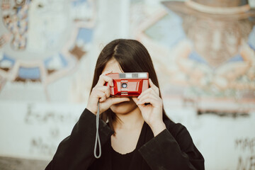 Mujer joven tomando fotografías con una cámara analógica. Concepto de gente, estilos de vida y...