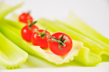Fresh green Celery and cherry Tomatoes on white background. Food for healthy concept. Blurry background.