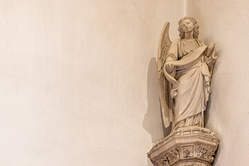 Beautiful ornate carved statue of an angel figure on a church wall with copy space