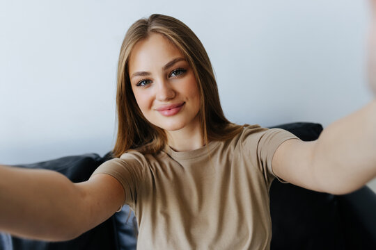 Portrait of beautiful woman taking a self-portrait with her smartphone at home.