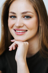 Obraz premium Portrait of a happy teen girl sitting on a couch in the living room at home