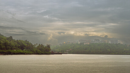 Beautiful monsoon landscape in Goa India from the San Jacinto island with ship building activities and barges docked on the port. - obrazy, fototapety, plakaty