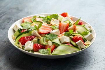Summer Strawberry, cucumber salad with lettuce, feta cheese and almonds. Healthy Food.