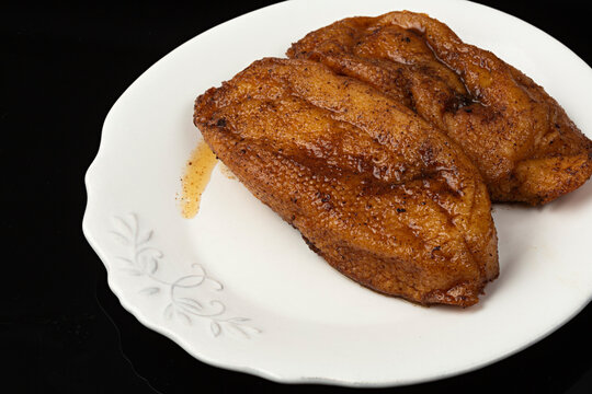 Torrijas en plato blanco sobre fondo negro.
