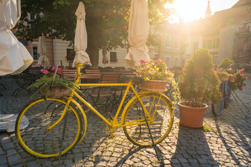 Fototapeta na wymiar Bicycle with flowers as a cafe decoration in medieval city Sighisoara, Romania