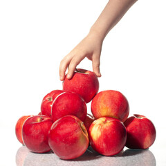 A group of red apples isolated on a white background, hand takes an apple