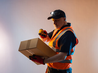 Storekeeper scans the data on the box. Warehouse storage. A courier with a barcode reader and a...