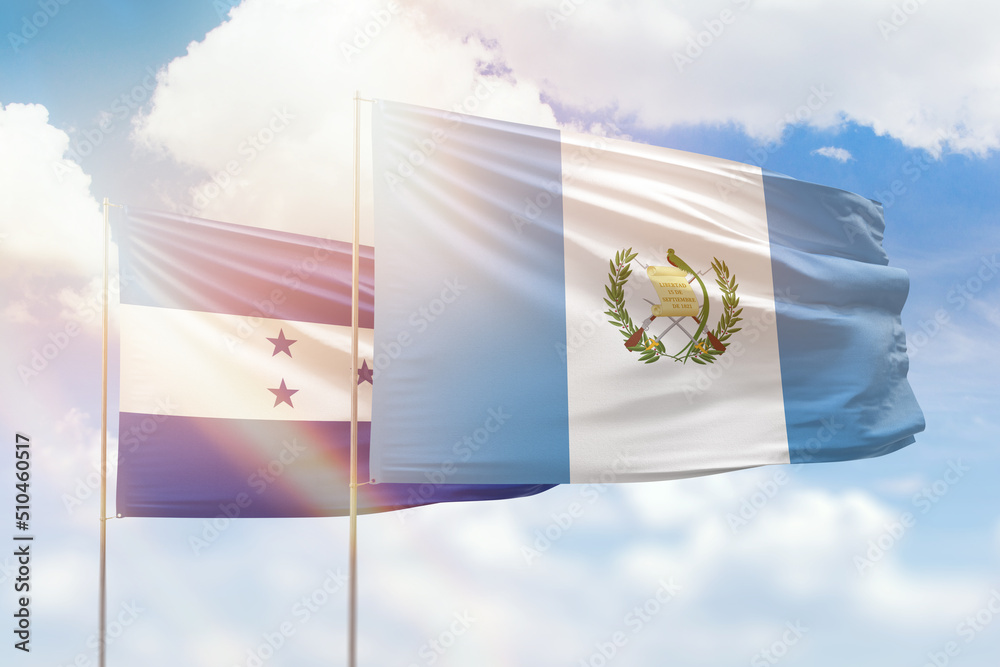 Wall mural sunny blue sky and flags of guatemala and honduras