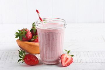 Strawberry smoothie. Vegan smoothie or milkshake from strawberry, banana and mint on white wooden table background. Clean eating, alkaline diet. Top view. Mock up.