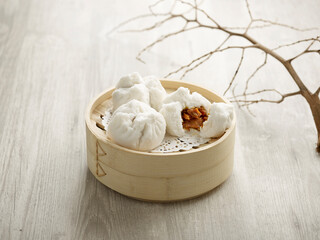 Steamed BBQ Pork bun with Oyster Sauce served in a wooden bowl isolated on mat side view on grey...