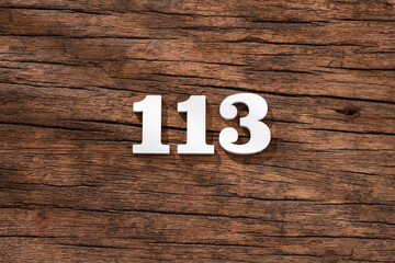 Number 113 in wood, isolated on rustic background