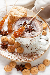 Fototapeta na wymiar Ceramic mug of hot chocolate, almond cookies and spices on wooden table
