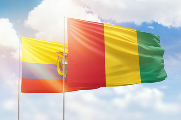 Sunny blue sky and flags of guinea and ecuador
