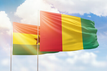 Sunny blue sky and flags of guinea and ghana