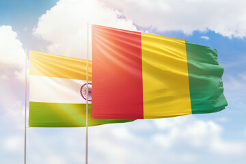 Sunny blue sky and flags of guinea and india