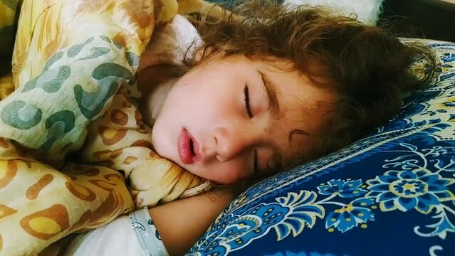 little girl sleeping on a big pillow